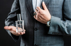 Man in suit holding botle of cologne